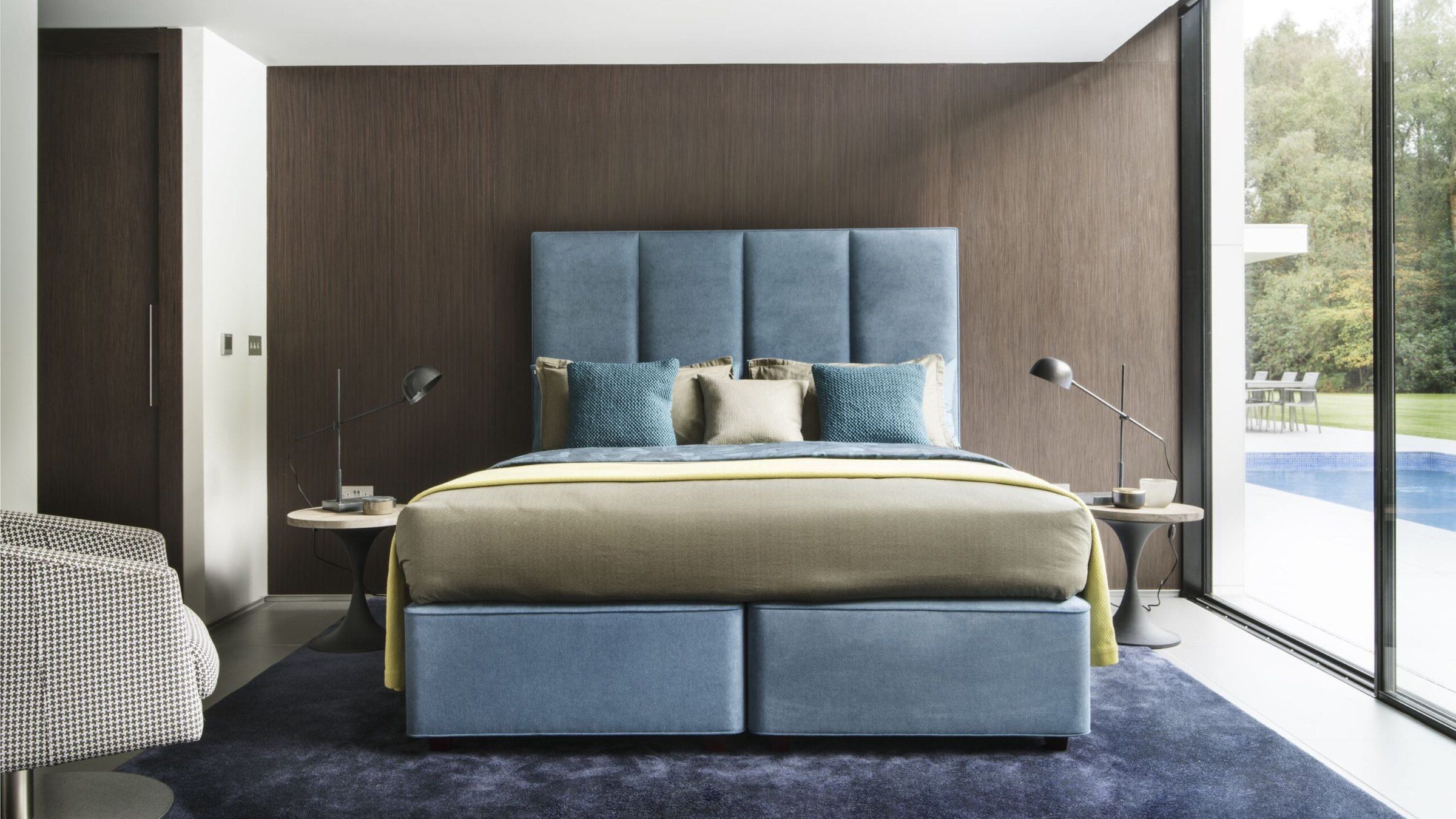Letto Hypnos con testiera imbottita azzurra in una camera contemporanea
