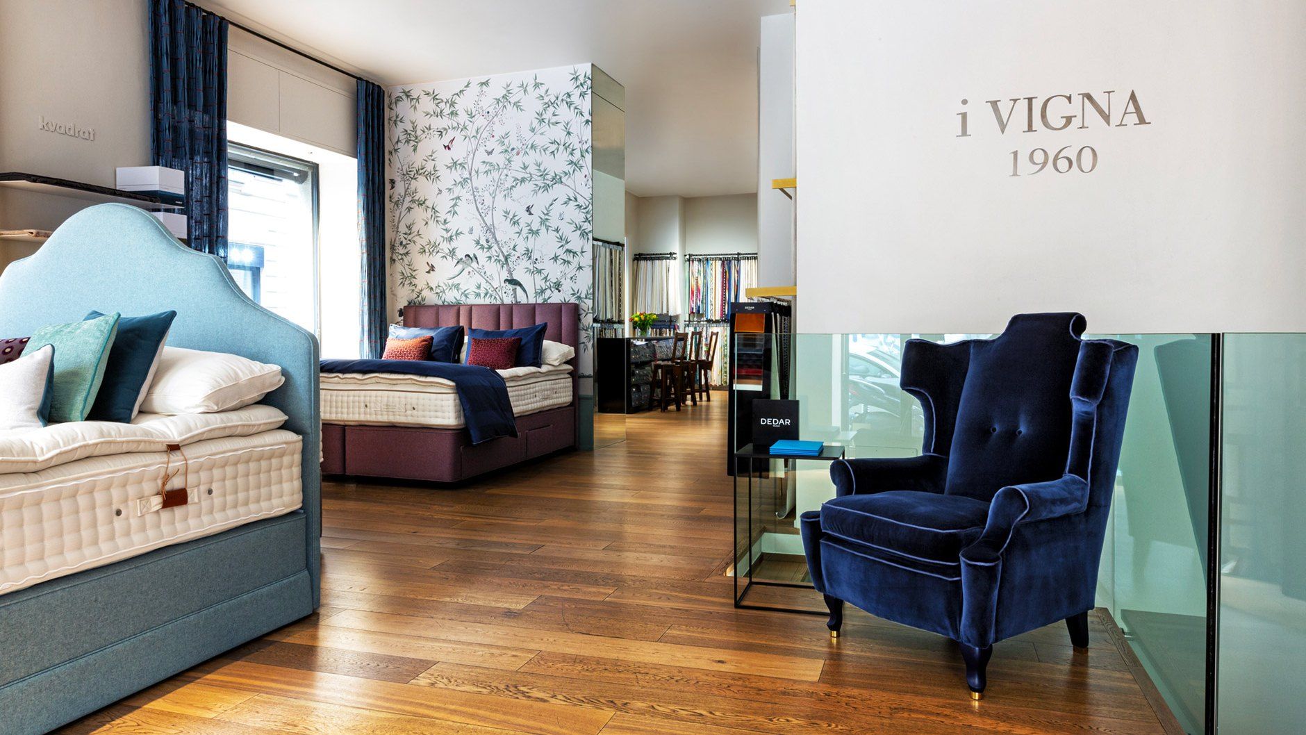 Lo showroom i Vigna: letti esposti, poltrona in velluto blu e l’insegna i Vigna 1960
